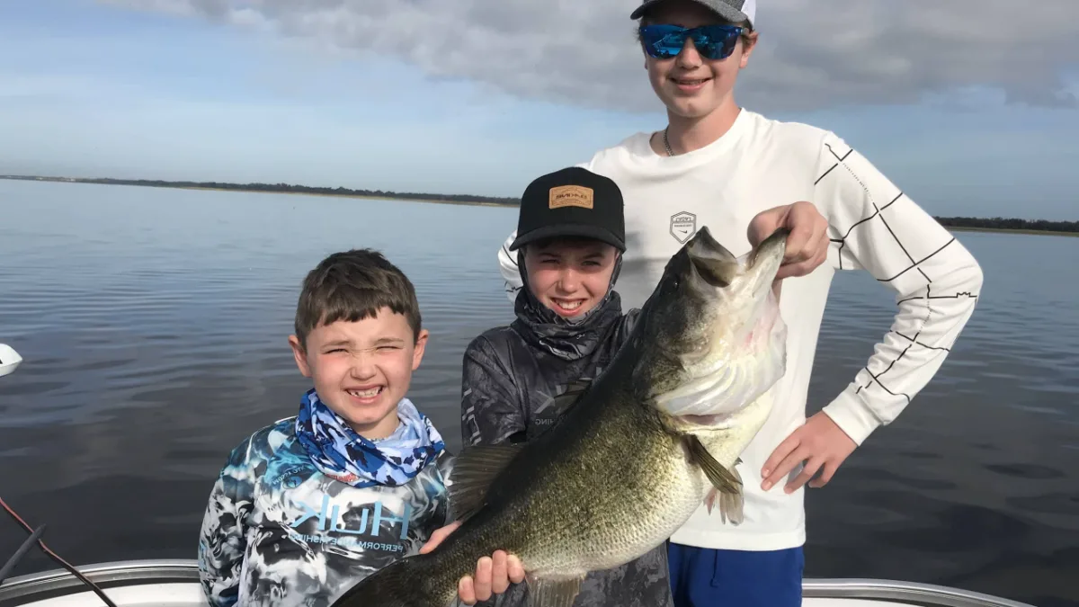 Kids holding a Lake Toho largemouth bass in Kissimmee