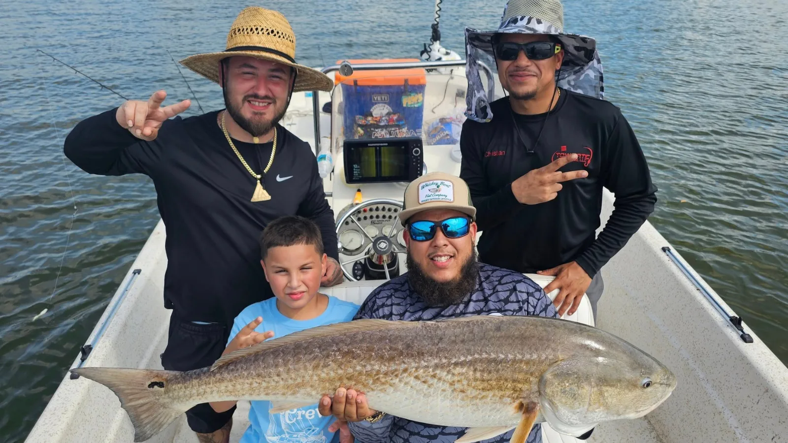 Family holding a big redfish on a New Smyrna Beach inshore trip